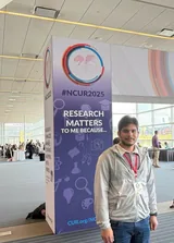 Me beside a Research Matters to Me Because pillar in the conference hall.