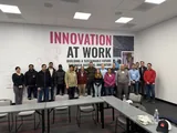 Me in the green shirt, with the visiting university and industry teams in front of an Innovation at Work wall.