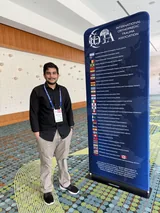 Me in the conference centre with my meeting badge on, standing beside the International Orthopaedic Trauma Association banner.