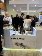 A crowded hand and wrist implant display case on the exhibit floor.