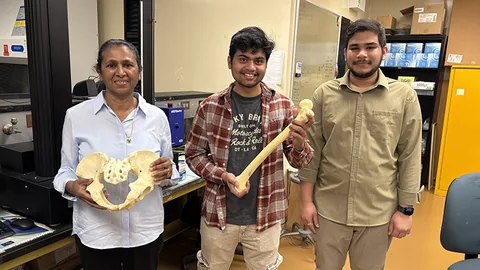 Dr. Champa Jayasuriya, Shyama Tripathy and me in the lab. Dr. Jayasuriya holds a pelvis model and Shyama a femur; I am on the right.